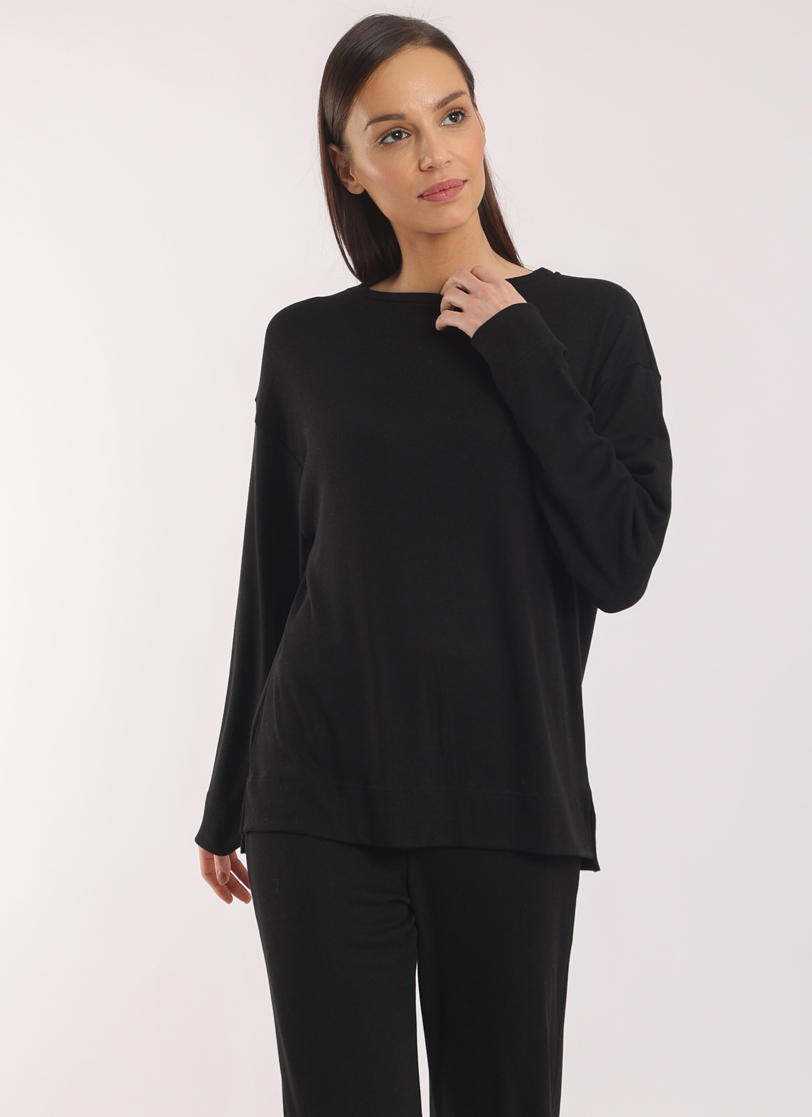 Žena stoji u crnoj majici na dugi rukav